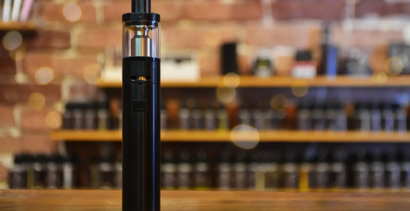 Détaillant examinant différents modèles de vaporisateurs CBD sur un comptoir de boutique professionnelle