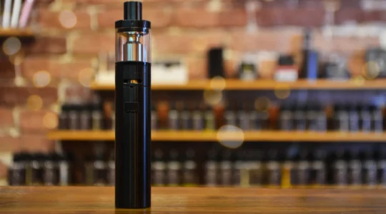 Détaillant examinant différents modèles de vaporisateurs CBD sur un comptoir de boutique professionnelle